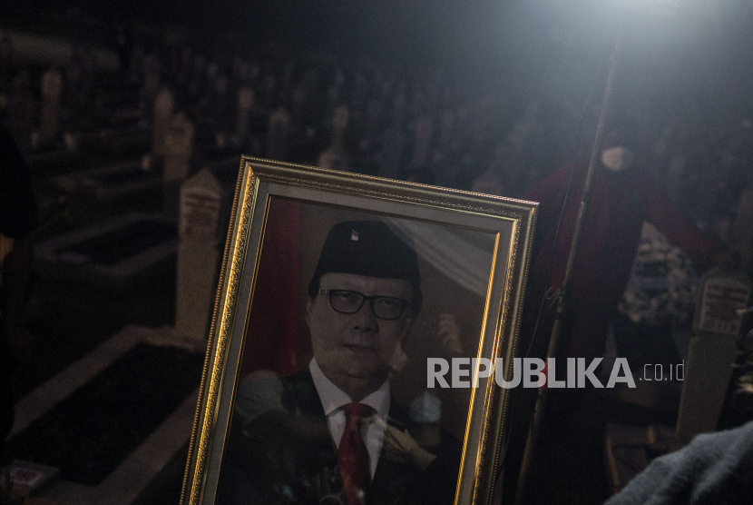 Pelayat berada di dekat foto almarhum Menteri Pendayagunaan Aparatur Negara dan Reformasi Birokrasi (PAN-RB) Tjahjo Kumolo seusai upacara pemakaman di Taman Makam Pahlawan Nasional Utama (TMPU) Kalibata, Jakarta, Jumat (1/7/2022). Tjahjo Kumolo meninggal dunia di Rumah Sakit Abdi Waluyo, Menteng, Jakarta, pada Jumat pukul 11.10 WIB setelah menjalani perawatan intensif di RS tersebut sejak pertengahan Juni 2022.