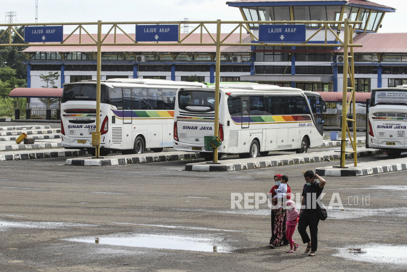 Sejumlah penumpang melintasi area parkir bus di Terminal Jatijajar, Depok, Jawa Barat. Pemkot Depok memastikan pembangunan Jembatan Jatijajar akan selesai pada 14 Februari.