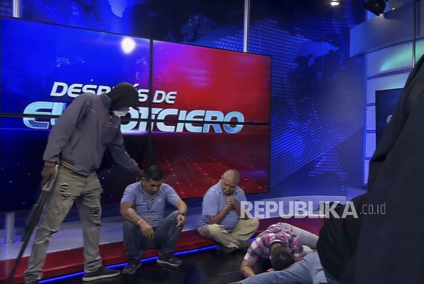 Tangkapan layar video langsung dari jaringan TC Television menunjukkan orang bertopeng dan bersenjata berdiri di depan wartawan selama siaran langsung, di Guayaquil, Ekuador, Selasa, (9/1/2024).
