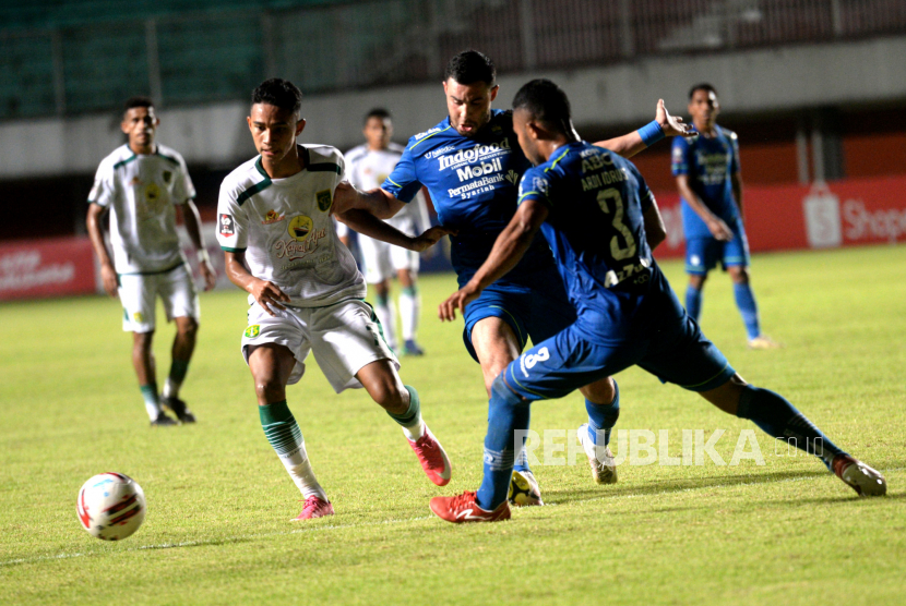 Penyerang Persebaya Merselino mencoba melewati bek Persib pada pertandingan lanjutan Piala Menpora 2021 di Stadion Maguwoharjo, Sleman, Yogyakarta, Ahad (11/4).