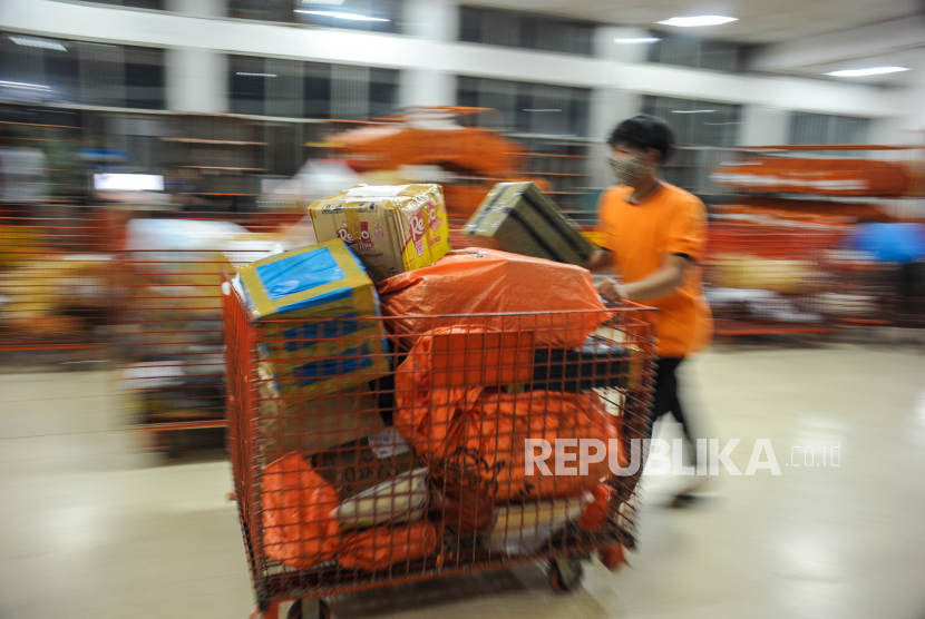 Pekerja melakukan pemilahan barang yang akan dikirim melalui PT Pos Indonesia. Kini di masa pandemi, layanan pengunjung di Kantor Pos tutu