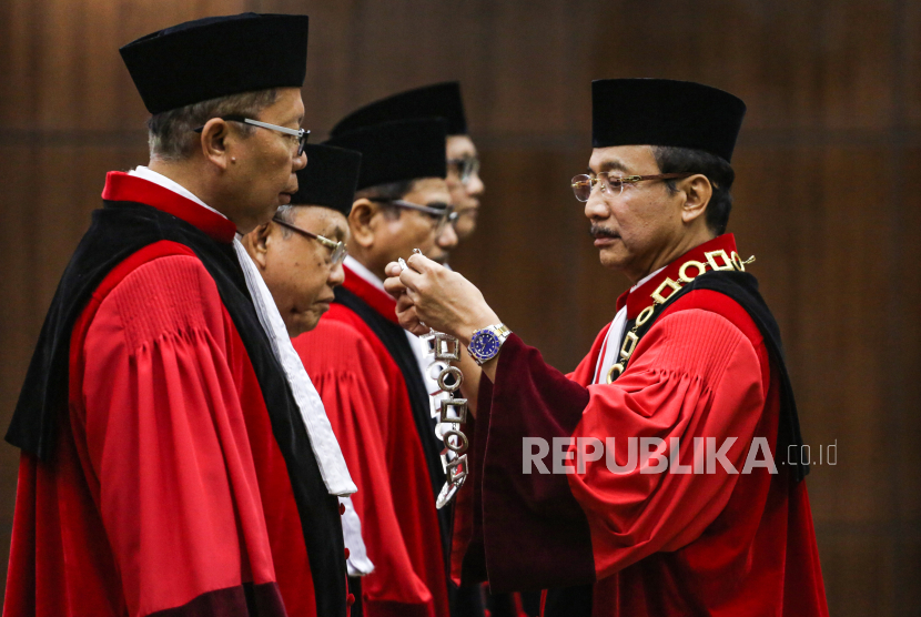Ketua Hakim Mahkamah Konstitusi (MK) Suhartoyo (kanan) menyerahkan kalung Hakim MK dari Hakim MK Wahiduddin Adams (kedua kiri) kepada Hakim MK yang baru Arsul Sani (kiri) saat pisah sambut Hakim MK di Mahkamah Konstitusi, Jakarta, Kamis (18/1/2024). Mahkamah Konstitusi menggelar Wisuda Purnabakti Wahiduddin Adams dan Manahan MP Sitompul serta menyambut Hakim Konstitusi yang baru Ridwan Mansyur dan Arsul Sani. 