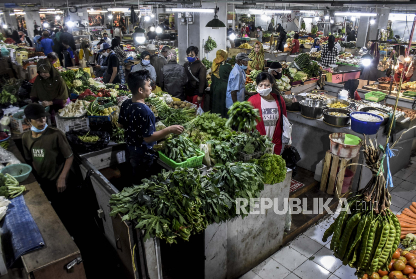 Warga berbelanja sayuran di Pasar Kosambi, Kota Bandung, Selasa (19/5). Meskipun sejumlah lapak atau kios menyediakan layanan pemesanan via daring, sebagian warga lebih memilih belanja langsung ke pasar di tengah pandemi Covid-19 karena alasan dapat memilih sediri kesegaran dari produk yang dibeli