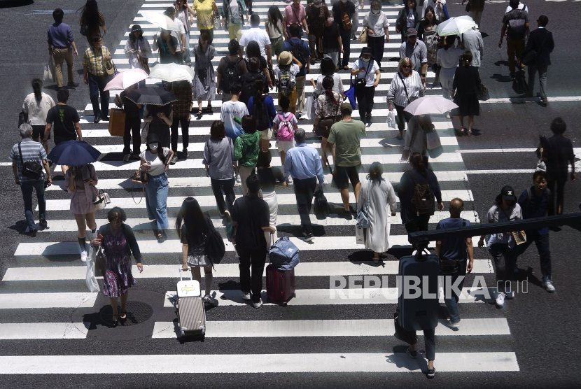 Orang-orang menggunakan payung saat cuaca panas di Tokyo. Rabu, 12 Juni 2024. 