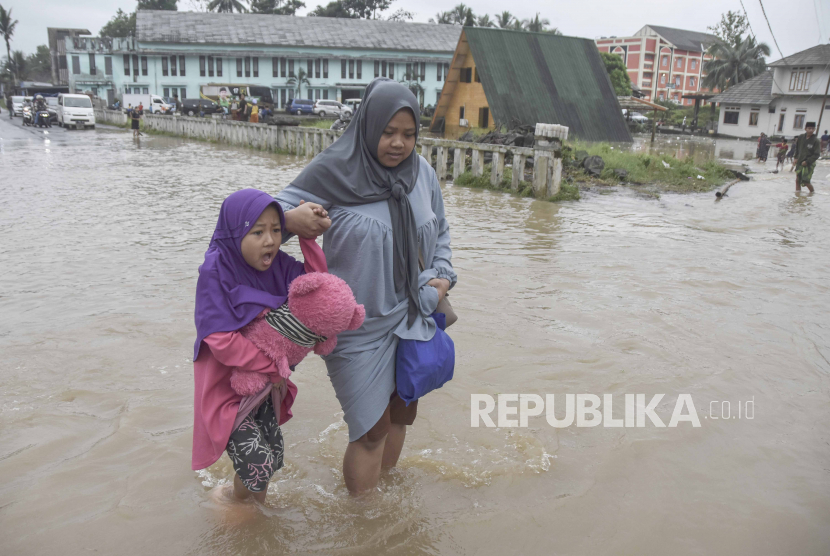 Santri menerobos banjir di Pondok Pesantren Miftahul Huda, Kecamatan Manonjaya, Kabupaten Tasikmalaya, Jawa Barat, Jumat (7/7/2023). Fenomena el nino berlangaung hingga Desember 2023.