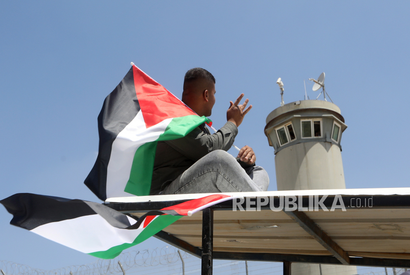  Pengunjuk rasa Palestina mengibarkan bendera Palestina (ilustrasi). Menteri Keamanan Nasional Israel Itamar Ben-Gvir mengatakan ia menginstruksikan polisi untuk menyingkirkan bendera Palestina dari ruang publik. 