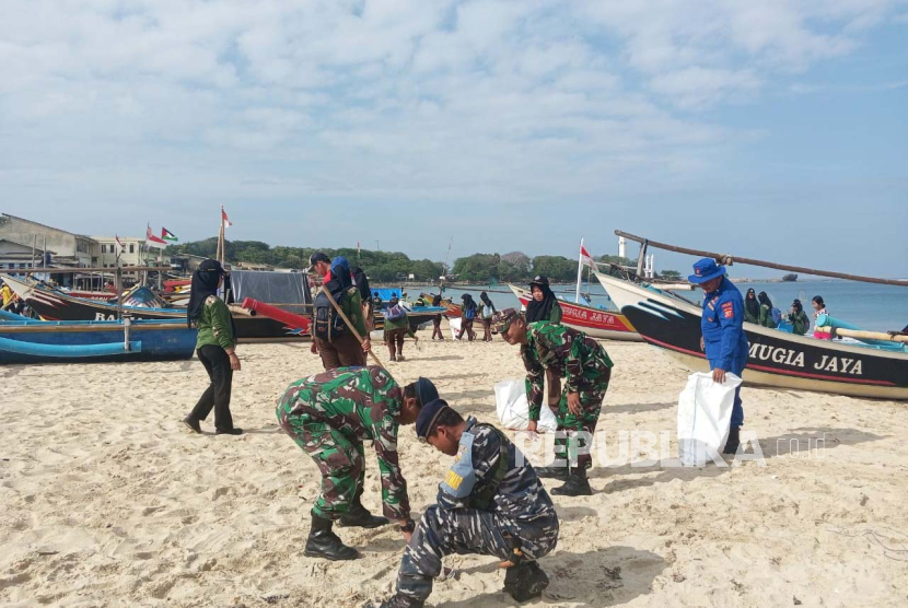 Petugas melakukan aksi bersih-bersih di Pantai Santolo, Kecamatan Cikelet, Kabupaten Garut, Ahad (26/11/2023).