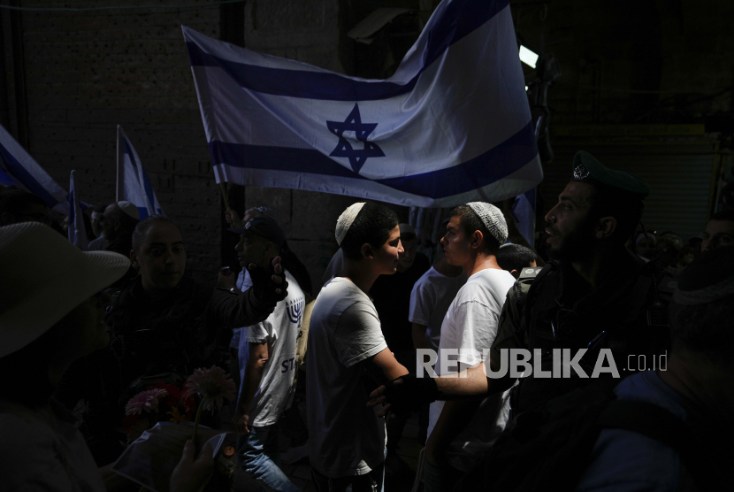 Warga Israel mengibarkan bendera di Yerusalem, Kamis (18/5/2023) untuk merayakan aneksasi Yerusalem pada 1967.