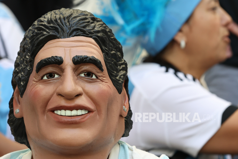 Seorang pendukung Argentina mengenakan topeng Diego Maradona sebelum pertandingan sepak bola, (ilustrasi).