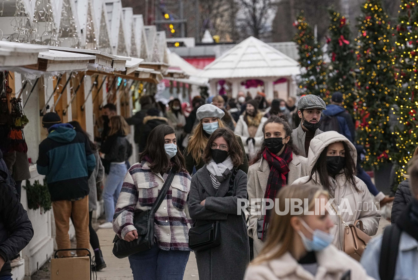  Pembeli yang mengenakan masker wajah untuk melindungi diri dari COVID-19 berjalan di sepanjang pasar Natal di taman Tuilerie di Paris, Senin, 20 Desember 2021. Negara-negara di seluruh Eropa telah bergerak untuk menerapkan kembali langkah-langkah yang lebih keras untuk membendung gelombang baru infeksi COVID-19 yang dipicu oleh varian omicron yang sangat menular.