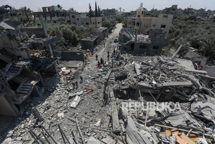 Warga Palestina memeriksa rumah mereka yang hancur di kamp pengungsi Al Maghazi, Jalur Gaza tengah, 15 April 2024, menyusul serangan udara Israel. 
