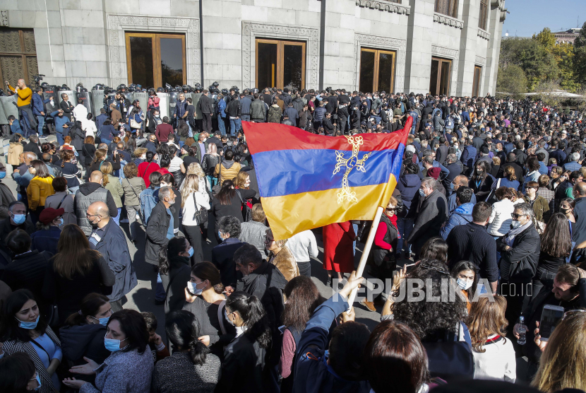  Para pengunjuk rasa mengibarkan bendera nasional Armenia selama protes menentang kesepakatan untuk menghentikan pertempuran di wilayah Nagorno-Karabakh, di Yerevan, Armenia, Rabu, 11 November 2020. 