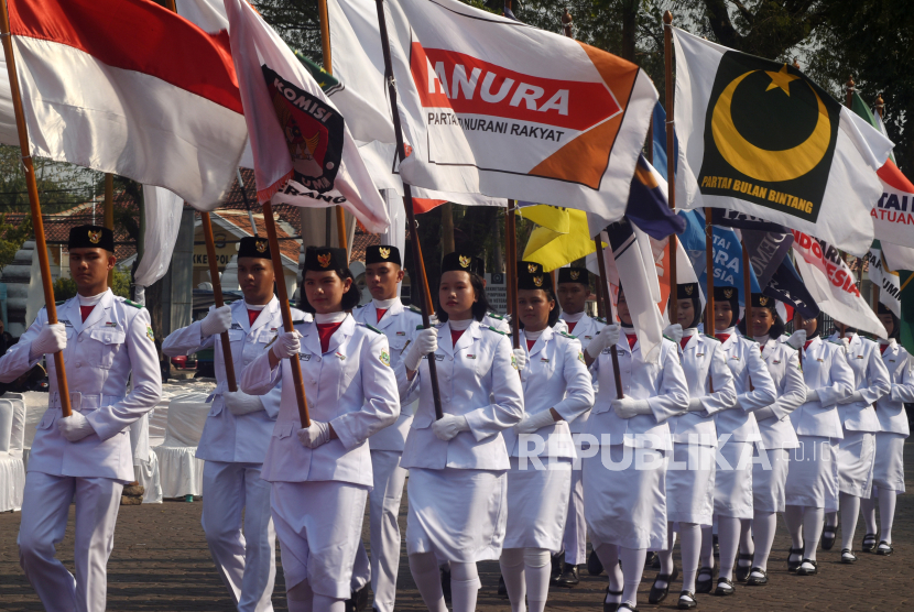 Sejumlah pelajar membawa bendera partai politik peserta Pemilu 2024 saat pawai sosialisasi Pemilu 2024 di Serang, Banten, Senin (30/10/2023). 