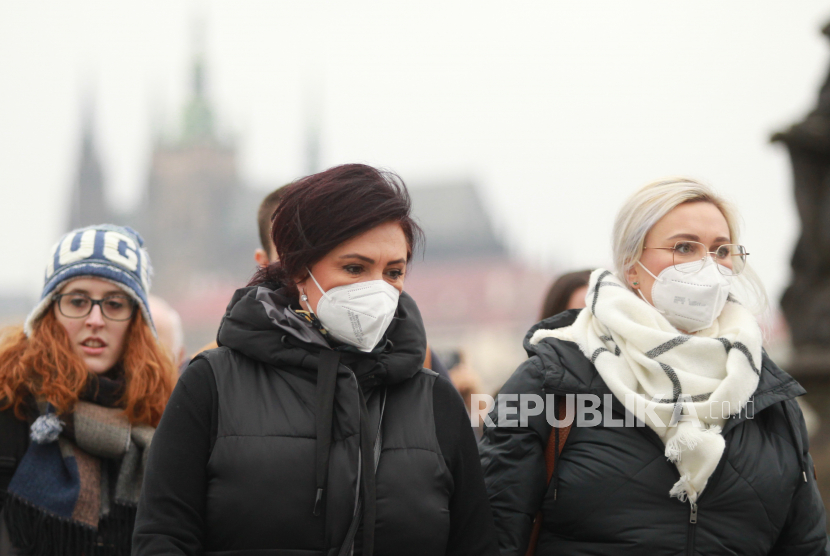 Wanita mengenakan masker pelindung wajah terlihat dari pintu di Jembatan Charles di Praha, Republik Ceko. Angka harian kasus Covid-19 di Ceko mencatatkan rekor akibat Omicron. Ilustrasi.