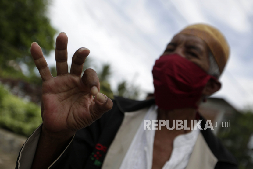 Seorang warga mengenakan masker yang dibagikan untuk melindungi para lansia di Banda Aceh, pada 1 Mei lalu.