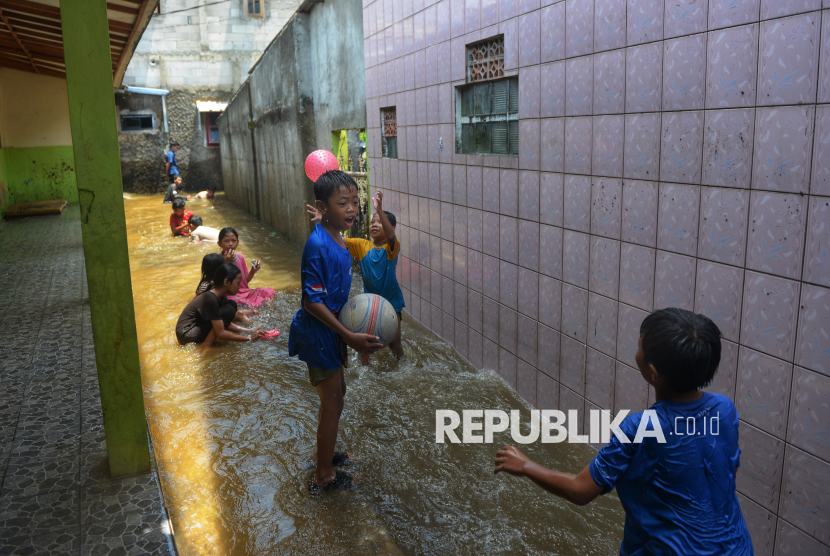 Anak-anak bermain air ketika banjir melanda kawasan RT 03 RW 06, Jati Padang, Pasar Minggu, Jakarta, Jumat (31/10/2025). Banjir yang terjadi sejak kemarin sore itu disebabkan oleh tingginya curah hujan di wilayah Jakarta di tambah dengan jebolnya Tanggul Baswedan di wilayah tersebut. Menurut salah satu warga, Iin, banjir terjadi sejak Kamis (30/10/2025) pukul 15.30 dengan ketinggian air mencapai satu meter. Iin berharap Tanggul Baswedan segera diperbaiki agar banjir tidak kembali merendam rumahnya.