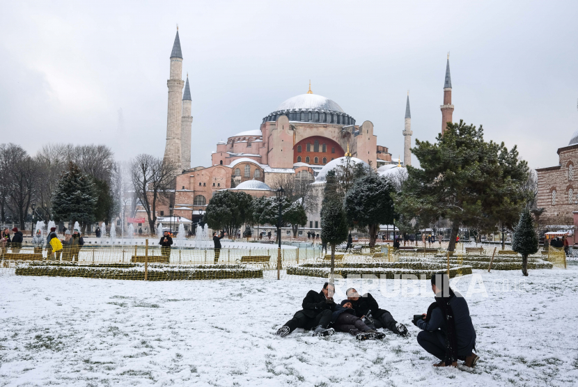 Orang-orang menikmati waktu mereka di depan Masjid Hagia Sophia pada hari bersalju di Istanbul, Turki, 18 Januari 2021.