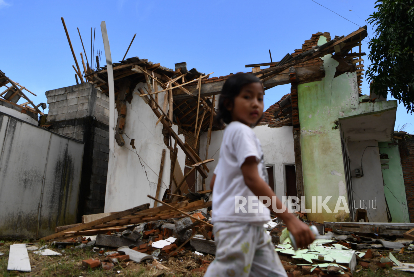 Seorang anak melintas di depan rumah yang rusak akibat gempa di Kabupaten Malang, Jawa Timur (ilustrasi)