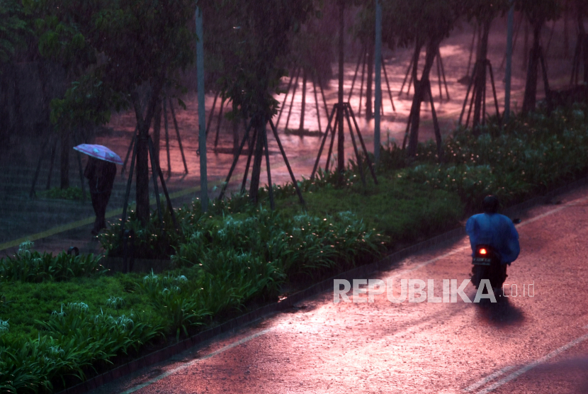 Seorang warga membawa payung saat melintas di Kawasan Senayan, Jakarta, Jumat (16/10/2020). Menurut Badan Meteorologi, Klimatologi dan Geofisika (BMKG) musim hujan di Indonesia telah berlangsung dari bulan Oktober dan diprediksi puncak musim hujan terjadi pada Januari hingga Februari 2021. 