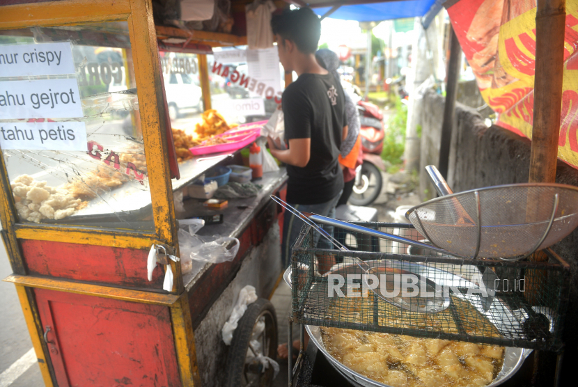 Penjual melayani pembeli gorengan, Ahad (20/3/2022). Sejak dicabutnya kebijakan Harga Eceran Tertinggi (HET) minyak goreng (migor), pedagang kecil dan menengah di Lampung merasakan dampak buruknya. 