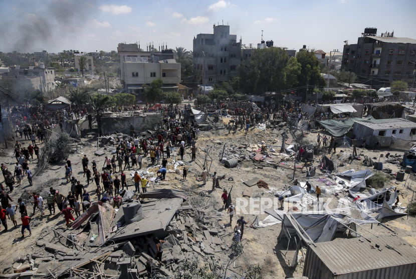 Warga Palestina memeriksa kerusakan di lokasi yang terkena pemboman di Khan Younis, Jalur Gaza selatan, Sabtu (13/7/2024). Menurut pejabat kesehatan setempat bahwa serangan udara Israel tersebut telah menewaskan setidaknya 90 warga Palestina di zona pengungsi camp kemanusiaan. Israel mengklaim serangan itu dilakukan untuk menargetkan panglima militer Hamas Mohammed Deif. 