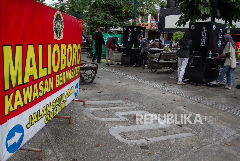 Wisatawan mencuci tangan sebelum memasuki kawasan Malioboro di Yogyakarta, Senin (14/12/2020). Pemerintah Kota Yogyakarta menambahkan 34 instalasi cuci tangan dengan empat kran setiap instalasi yang tersebar di sejumlah titik jalur pedestrian Malioboro guna menekan penularan COVID-19 menjelang liburan akhir tahun 2020. 