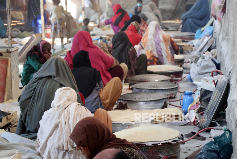  Wanita Afghanistan bekerja di sebuah toko roti yang memproduksi roti di Kandahar, Afghanistan, 13 Januari 2022. Sebuah perusahaan swasta yang memproduksi roti telah memberikan kesempatan kerja kepada 55 wanita Afghanistan yang membuat 5.000 unit roti sehari, yang dijual oleh perusahaan di kota tersebut . Kekurangan pangan akut yang dipicu oleh kekeringan, kekurangan uang tunai, pandemi, dan layanan kesehatan yang lumpuh telah menumpuk kesengsaraan pada orang-orang Afghanistan.
