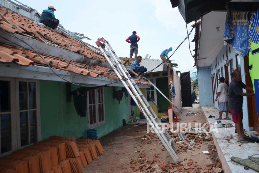 Warga memperbaiki bangunan yang rusak akibat tersapu angin puting beliung (Ilustrasi)