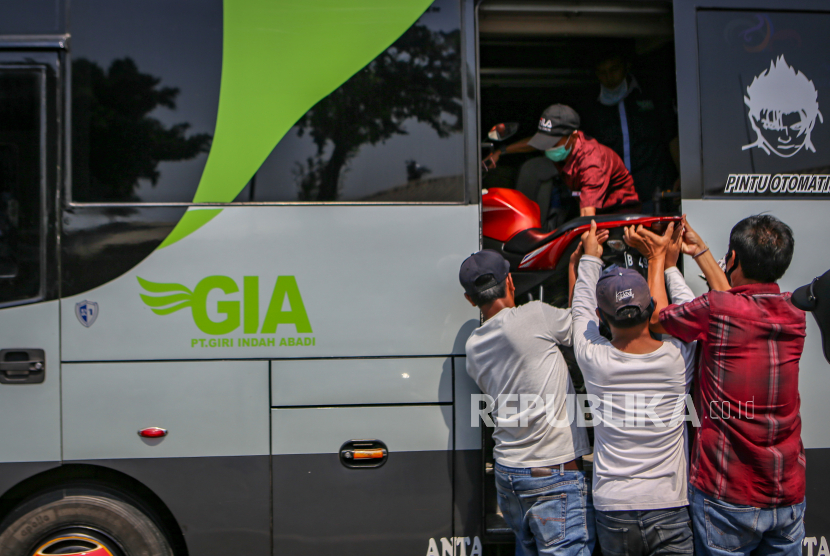 Petugas bus menaikkan motor ke dalam bus di Terminal Kalideres, Jakarta, Rabu (22/4/2020). Presiden RI Joko Widodo memutuskan untuk melarang mudik lebaran 2020 di tengah pandemi COVID-19 mulai 24 April guna mencegah perluasan penyebaran COVID-19 di wilayah Indonesia