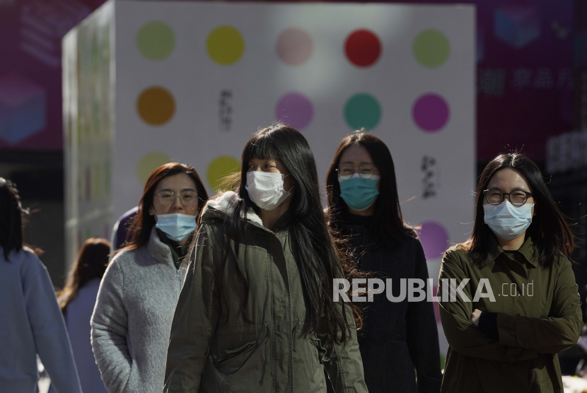  Warga memakai masker saat menyeberang jalan di Beijing, ilustrasi