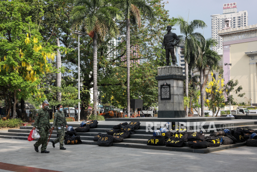 Petugas polisi berjalan di sepanjang monumen Liwasang Bonifacio di Manila, Filipina.