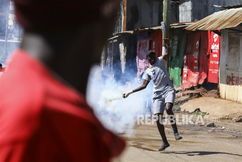  Pendukung oposisi Koalisi Azimio melempar batu dan meneriakkan slogan-slogan ke arah polisi anti huru hara (tidak ada dalam foto) selama protes nasional di Nairobi, Kenya, Senin (27/3/2023). 