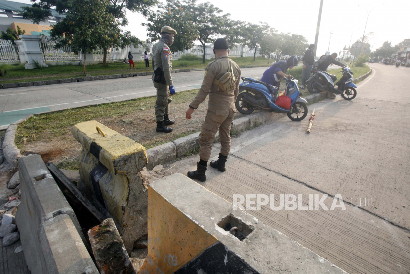 Sejumlah pengendara sepeda motor berupaya terobos pembatas jalan yang ditutup di Bogor, Jawa Barat.