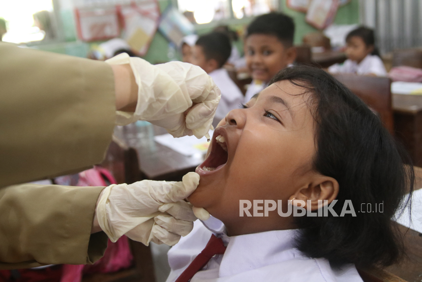 Petugas kesehatan memberikan imunisasi polio kepada siswa di SD Negeri Tempurejo 1, Kediri, Jawa Timur, Senin (15/1/2024). Layanan imunisasi dengan sistem jemput bola di sekolah tersebut sebagai upaya menyukseskan program pemerintah pemberian imunisasi polio serentak dalam menanggulangi kejadian luar biasa (KLB) polio. 