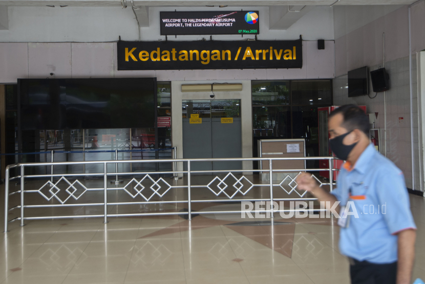 Warga berjalan di pintu kedatangan Bandara Halim Perdanakusuma yang tertutup di Jakarta, Kamis (7/5/2020). Meski penerbangan domestik dengan ketentuan khusus mulai dibuka, Bandara Halim Perdanakusuma masih belum melayani penerbangan domestik