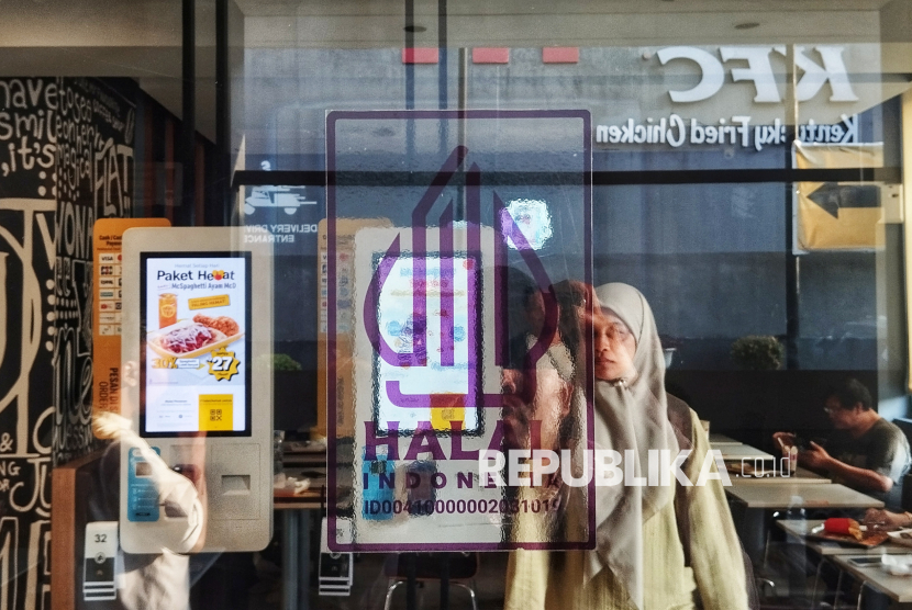 Pelanggan melintas di dekat Logo Halal di Sebuah Restoran Cepat Saji, Jakarta.
