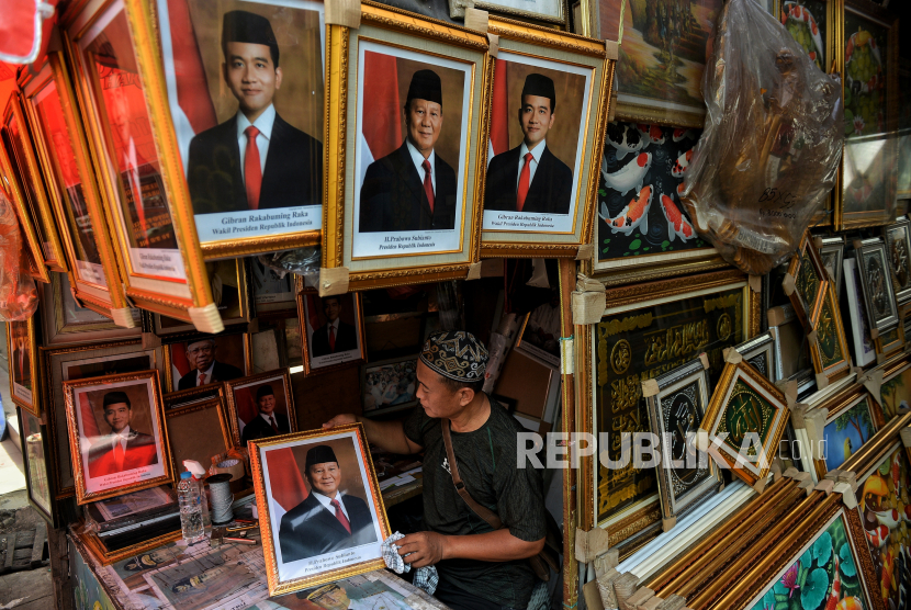 Pedagang melayani pembeli bingkai foto pasangan Prabowo-Gibran sebagai Presiden dan Wakil Presiden 2024-2029 di kawasan Pasar Baru, Jakarta, Selasa (23/4/2024).