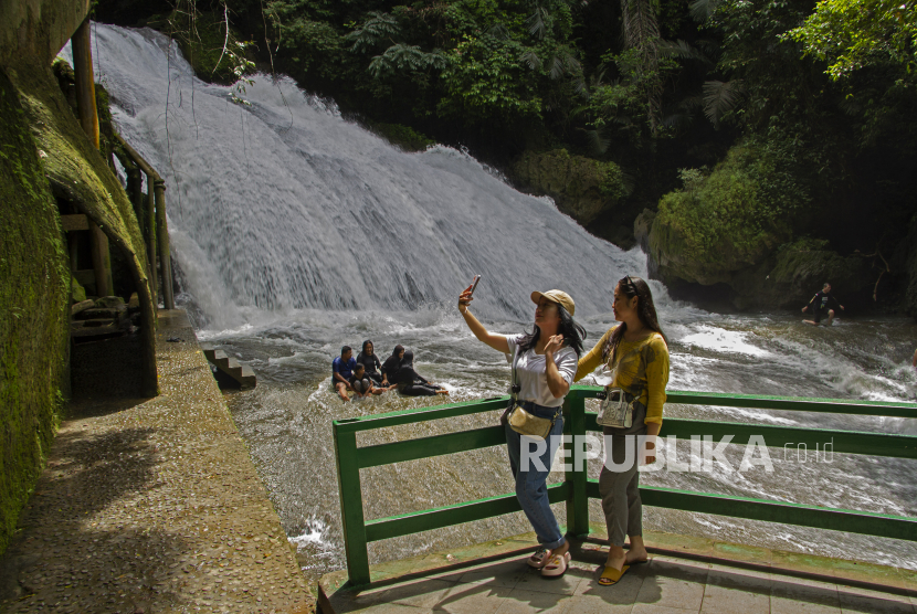 Pengunjung berswafoto di objek wisata alam Bantimurung yang berada di dalam kawasan Geopark Maros-Pangkep di Kabupaten Maros, Sulawesi Selatan, Sabtu (5/11/2022). Geopark tersebut telah disetujui dan direkomendasikan sebagai anggota baru UNESCO Global Geopark melalui rapat Dewan Council Geopark UNESCO.