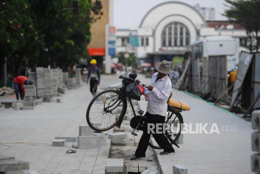 Pekerja menyelesaikan proyek revitalisasi pedestrian di kawasan Kota Tua, Jakarta Barat, Selasa (17/5/2022). Dinas Bina Marga DKI Jakarta merevitalisasi pedestrian dengan  memperlebar menjadi tiga meter sehingga cukup luas untuk para pejalan kaki. Trotoar nantinya juga akan dilengkapi dengan ubin pengarah (guidingblock) serta jalur khusus sepeda. revitalisasi tersebut ditargetkan rampung pada Juli 2022. 
