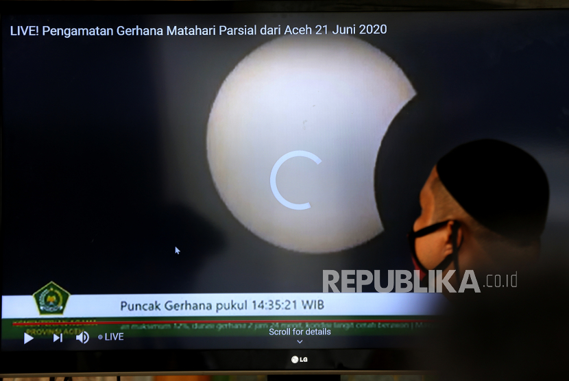 Petugas pemantauan gerhana matahari sebagian dari Kementerian Agama Aceh melintas didepan layar monitor di Banda Aceh, Aceh, Ahad (21/6/2020). Awal kontak gerhana di wilayah Aceh terjadi pukul 13