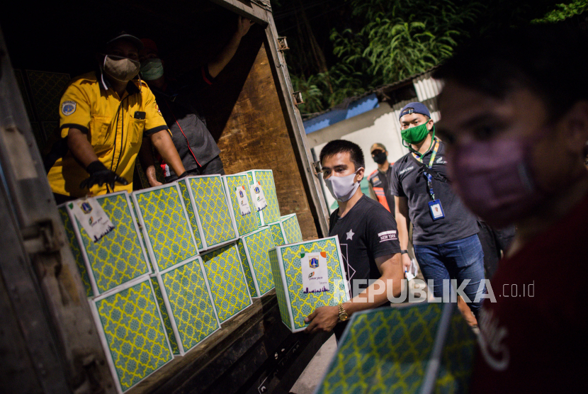 Petugas menyerahkan bantuan sembako kepada warga sebagai bantuan pangan akibat wabah Covid-19 di Jakarta.