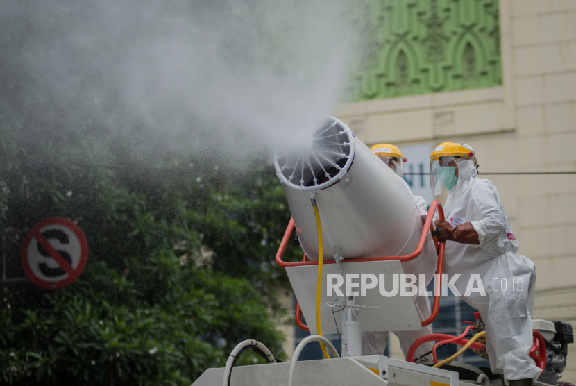 Petugas Palang Merah Indonesia (PMI) Jakarta Pusat menyemprotkan cairan disinfektan.