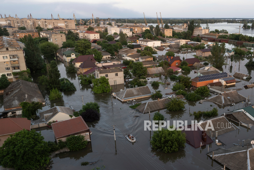 Orang-orang menaiki perahu karet di kawasan banjir di Kherson, Ukraina, Rabu, 7 Juni 2023. 600 kilometer persegi wilayah Kherson di Ukraina selatan terendam air.