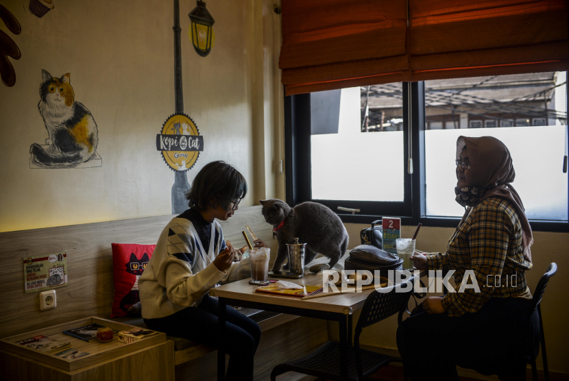 Pengunjung saat menikmati hidangan di salah satu kafe di kawasan Kemang, Jakarta.