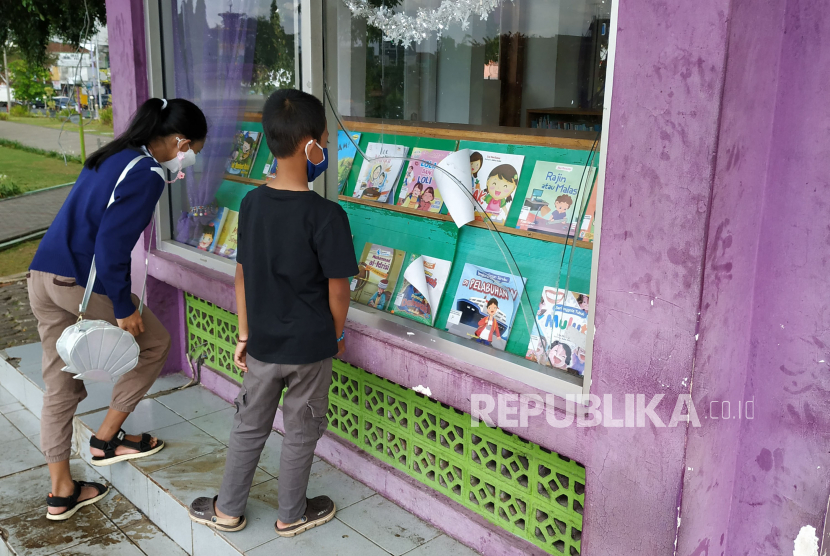 Sejumlah anak melihat koleksi buku di luar perpustakaan Alun-alun Kota Ciamis, Ahad (13/6). Di masa pandemi, perpustakaan mini tersebut tutup sementara untuk mencegah penyebaran Covid-19