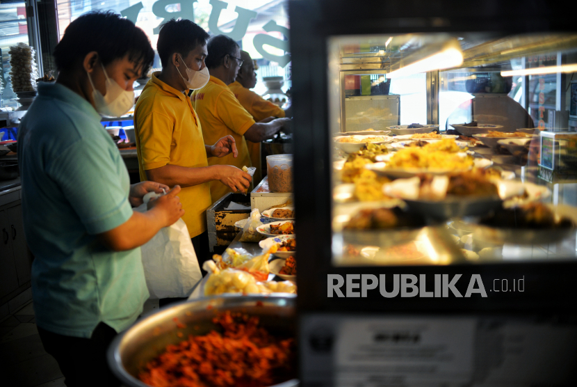 Pramusaji menyiapkan hidangan untuk konsumen di Rumah Makan Padang Surya di Jalan Bendungan Hilir, Jakarta, Kamis (12/1/2023). 