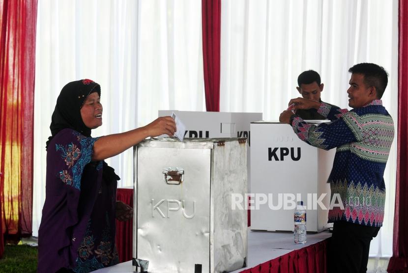 Warga memasukan surat suara pada Pilkada serentak 2018 di TPS 017, Desa Bojong Koneng, Babakan Madang, Bogor, Jawa Barat, Rabu (27/6).