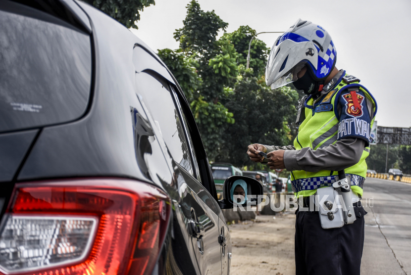 Petugas kepolisian memeriksa identitas pengemudi. Ilustrasi