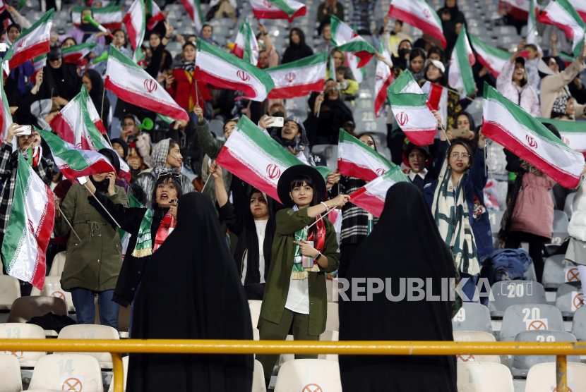 Polisi wanita Iran mengawasi para penggemar wanita saat pertandingan sepak bola persahabatan antara Iran dan Rusia di stadion Azadi di Teheran, Iran, (23/3/2023). Otoritas Iran memasang kamera pengawas (CCTV) di tempat umum dan jalan raya untuk mengidentifikasi, serta menghukum perempuan yang tidak mengenakan pakaian sesuai aturan negara.