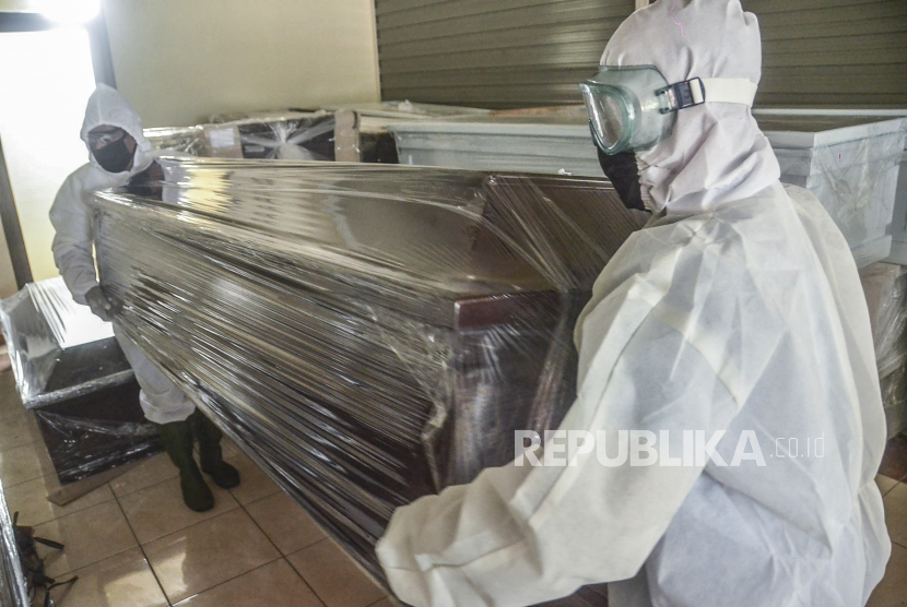 Sejumlah petugas merapikan peti khusus jenazah COVID-19 di rumah duka Dharma Agung, Bekasi, Jawa Barat, Rabu (1/4/2020). 